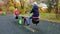 Happy boy and girl ride on swings on playground in autumn