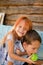 Happy boy and girl on a swing in the garden. Sister feeds her brother green apples. Laughing children, happy childhood