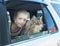 Happy boy and his companion cat in the car