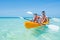 Happy boy and his father kayaking at tropical sea on yellow kayak