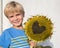 happy boy holding a dried ripe sunflower with a heart carved on it