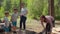 Happy boy jumping joyfully. Two women and two boys having summer camping vacation in forest. Family of two mothers and