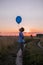 Happy Boy makes his wishes and dreams Outdoors with Helium Balloons. Run along the yellow field. Beautiful summer card, birthday