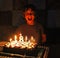 Happy boy near the cake for his eighth birthday, chess player