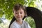 Happy Boy playing on a Swing wheel in the garden. Sunny summer day. activity for kids. Preschooler child having fun and swinging