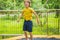 Happy boy plays outdoors in garden jumping high in the sky on trampoline