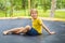 Happy boy plays outdoors in garden jumping high in the sky on trampoline