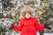 Happy boy plays with snow. Cute kid throwing snow in a winter park. Happy winter holidays. Winter fashion