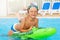 Happy boy riding inflatable toy in the pool