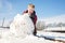 Happy boy rolling huge snowball