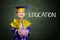 Happy boy with scholar gown and piggy bank