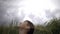 Happy Boy Sits In A Wheat Field And Looks At The Rainy Beautiful Sky