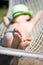 Happy boy sleeps in hammock at garden. Focus on feet