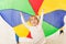 Happy boy standing under parti-colored parachute