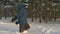 Happy boy teenager walking through snowdrift in winter forest. Winter activity