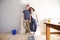 Happy boyfriend and girlfriend standing by wall with paint brush