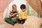 Happy boys reading book in kids tent at home