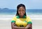 Happy brazilian woman in a soccer jersey at beach