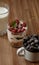 Happy breakfast. A small mug with blueberries, a glass of milk and granola with raspberries. Wooden background.