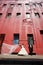 Happy bridal couple standing on sidewalk below tall red building