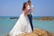 Happy bride and groom hug on the rocks in the Indian Ocean. Wedding and honeymoon in the tropics on the island of Sri Lanka.