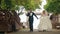 Happy bride and groom running and laughing on a wooden bridge in the park at the wedding walk