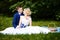 Happy bride and groom on their wedding sits on grass in park