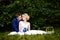 Happy bride and groom on their wedding sits on grass in park