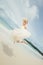 Happy bride jumping in wedding dress at the sea. young happy woman on beach.