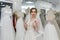 Happy bride tries on a wedding dress in salon