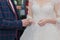 Happy bridegroom puts ring on bride at wedding registration.