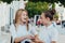 Happy bright positive moments of two stylish girls hugging and looking at the phone, discussing something on the street in the