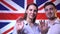 Happy british family handsome man and woman on british flag background, smiling and waving. British family concept