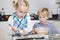 Happy brother and sister baking cookies in kitchen