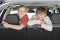 Happy Brother And Sister Leaning On Car Seat