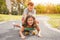 Happy brother and sister playing with longboard outdoor - Young people having fun in summer time outside - Youth, love, family and