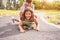 Happy brother and sister playing with longboard outdoor - Young people having fun in summer time outside - Youth, love, family and