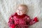 Happy brothers, baby and preschool children, hugging at home on white blanket, smiling