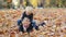 Happy brothers having fun together outdoors. Children playing with autumn leaves.