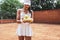 Happy brunette tennis woman holding a bunch of tennis balls