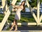Happy brunette woman dress relaxing fun leaning on wooden piles park enjoy your vacation, fashion style urban life.