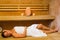 Happy brunette woman lying in a sauna