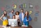 Happy business people at a desk standing against grey background with graphics