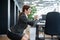 Happy business woman squat in open space office. A red-haired smiling female employee in a skirt and high heels does