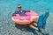 Happy businessman in flippers on an inflatable donut in the sea. Summer vacation concept