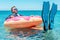 Happy businessman in flippers on an inflatable donut in the sea. Summer vacation concept