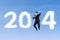 Happy businessman jumping with clouds of 2014