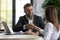 Happy businessman shaking hands with woman job seeker near laptop.