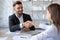 Happy businessman shaking hands with woman job seeker in suit.