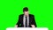 Happy businessman sitting at the table. Green screen